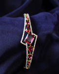 Elegant bracelet with red ruby gemstones on a dark fabric background