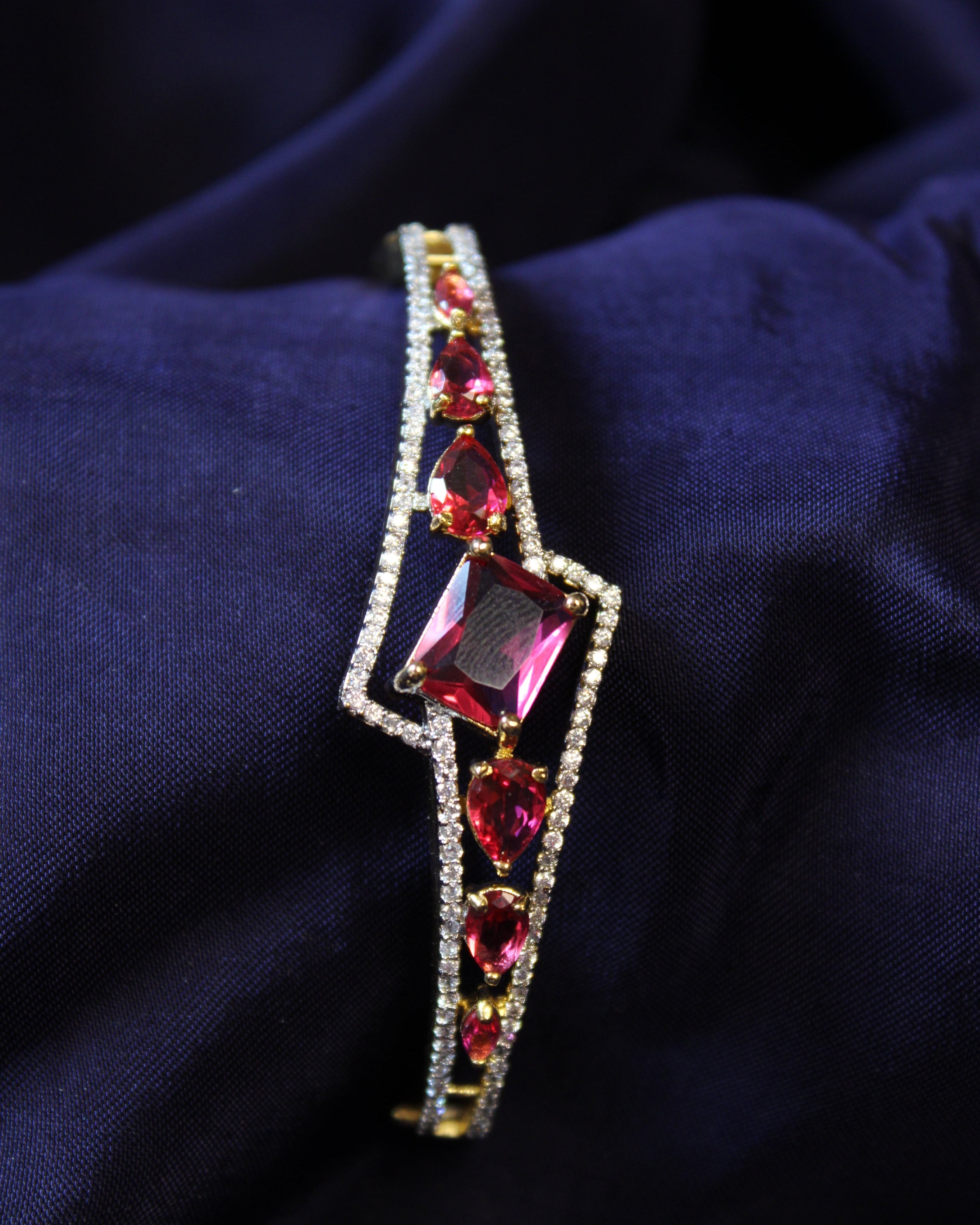 Elegant bracelet with red ruby gemstones on a dark fabric background