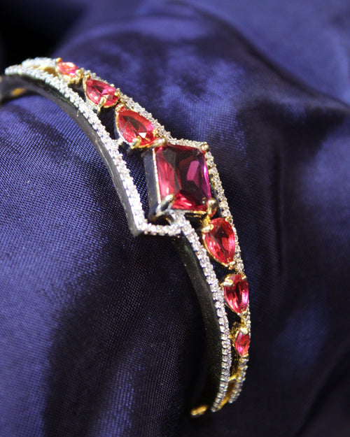 Jeweled bracelet with red gemstones on a dark blue fabric background