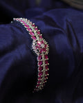 Jeweled bracelet with red ruby stones on a dark blue fabric background